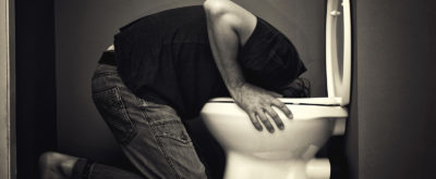 Man vomiting in toilet bowl