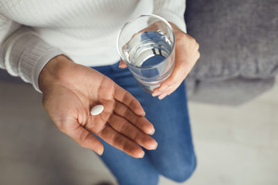 Pills tablet in hand of the girl in the room. Concept virus cold pill sick flu sickness headache flu illness.